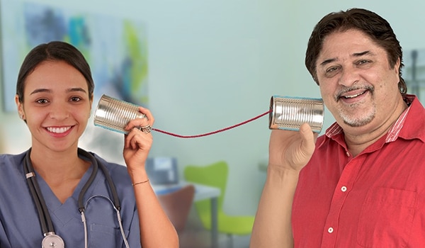 Photo depicting the telephone game with woman holding can next to her ear with string connected to another can that man is holding next to his ear. 