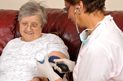 一位女性正在接受健康护理专业人士的血压检查。