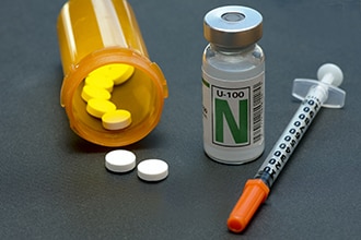 Butelka z tabletkami na receptę, strzykawka i linia insulinowa.