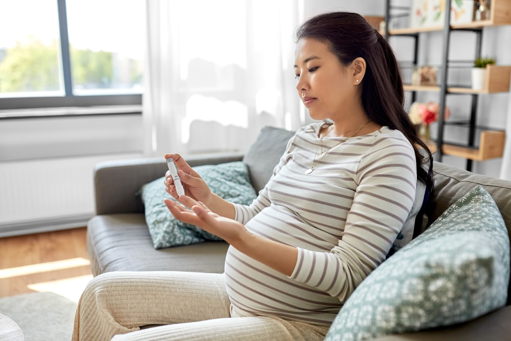 Pregnant woman checking her blood glucose level.