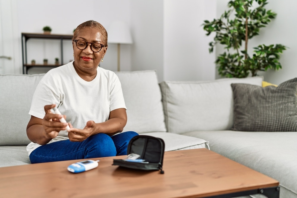 A woman checking her blood glucose level with a blood glucose meter.