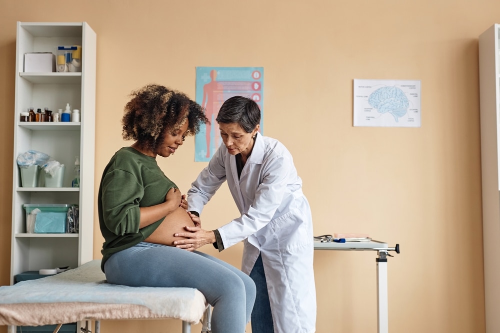 Health care professional checking a pregnant woman.