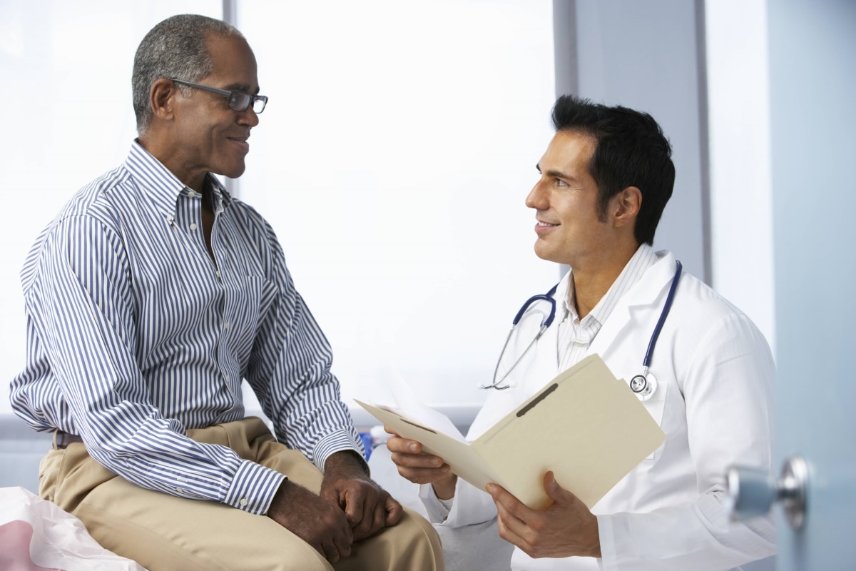 A man talking with a doctor in an exam room.