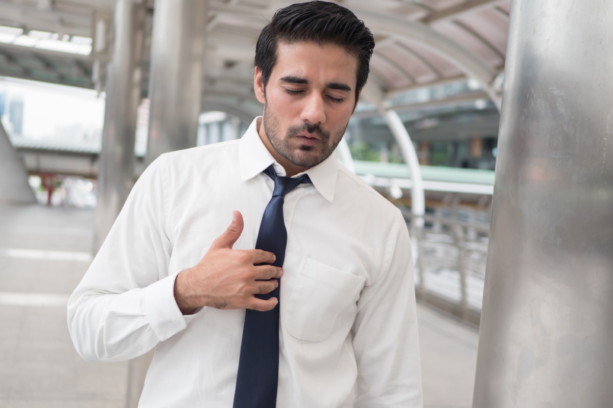 A man presses on his chest in pain.