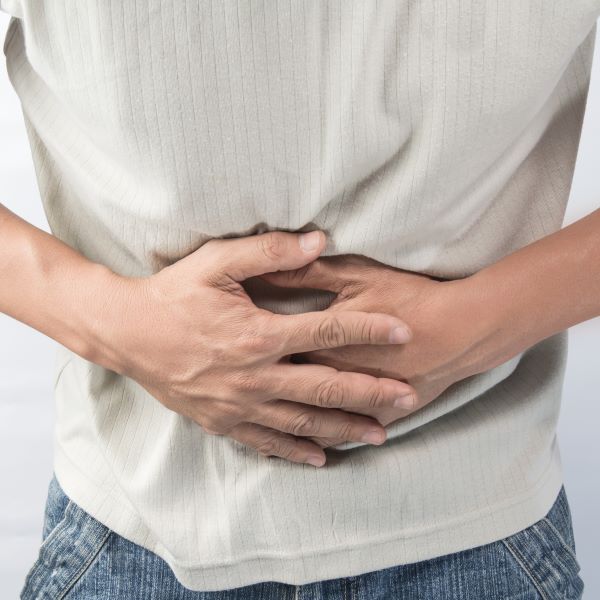 Person holding hands against stomach.
