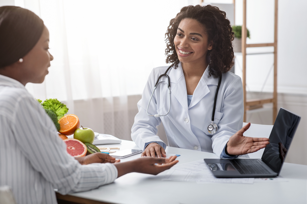 Doctor and patient talking in a doctor’s office.