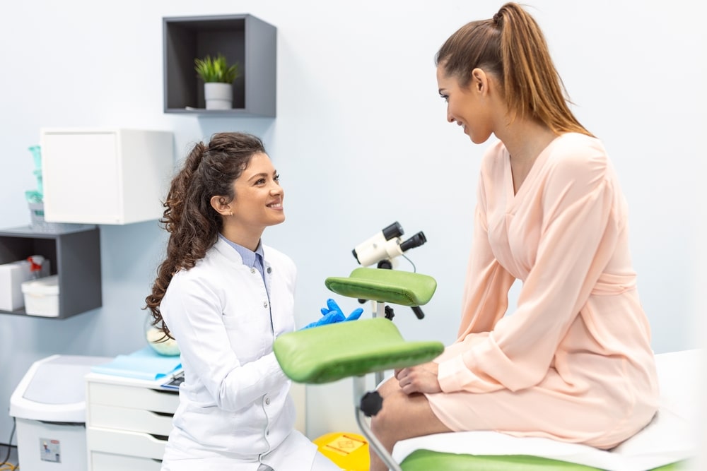 A patient and health care professional talking in an exam room.