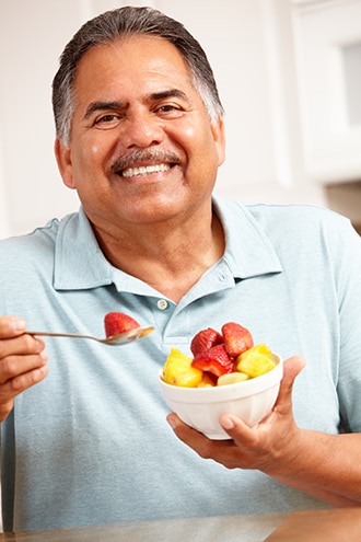 Un hombre consume frutas frescas en una taza.