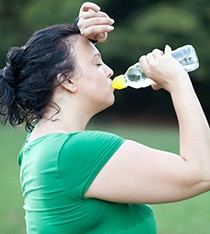 一位妇女在运动后出汗后喝水