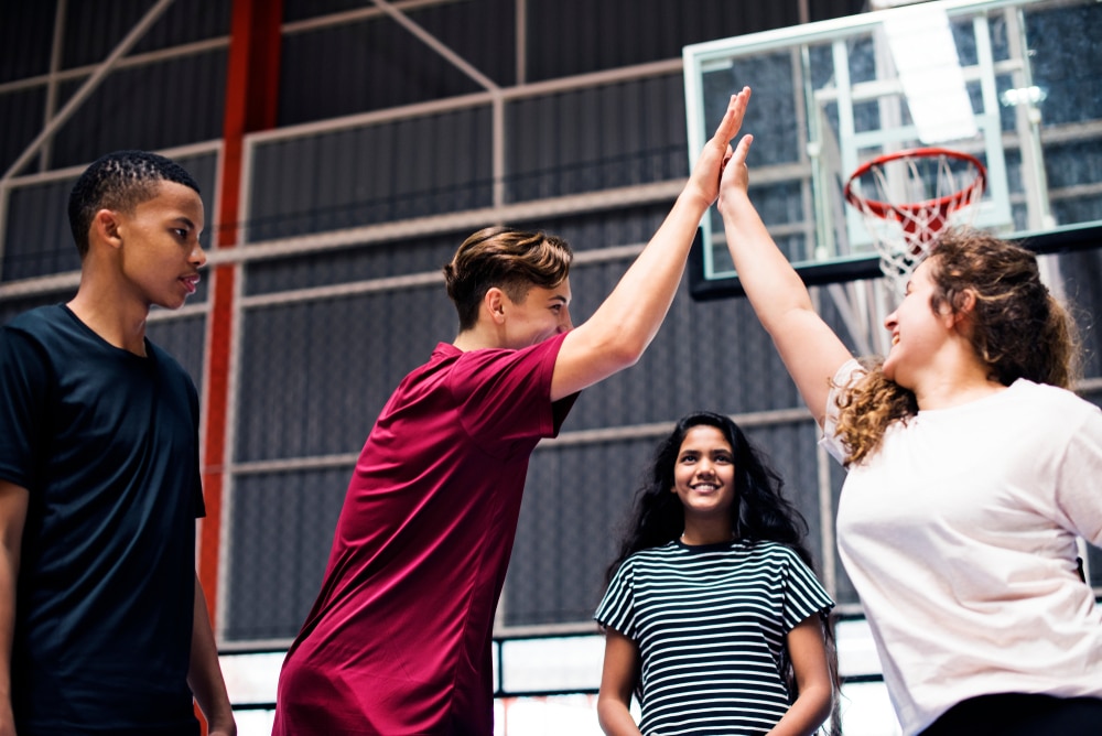 Unos adolescentes celebran en una cancha de baloncesto.