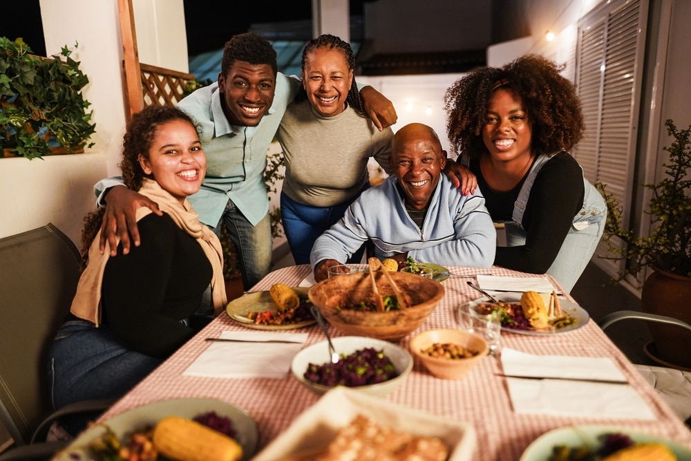 Una familia alrededor de una mesa, se prepara para disfrutar de una comida casera y saludable.