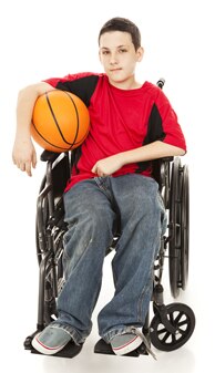 صورة لصبي يجلس على كرسي متحرك يحمل كرة سلة