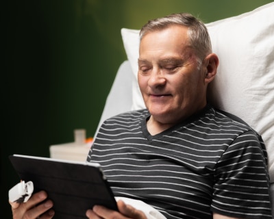 A man in a hospital room takes part in online behavioral therapy.