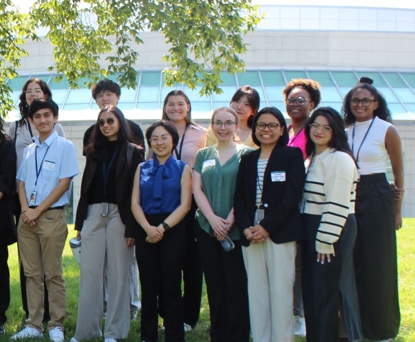 Fellows standing outside and smiling.