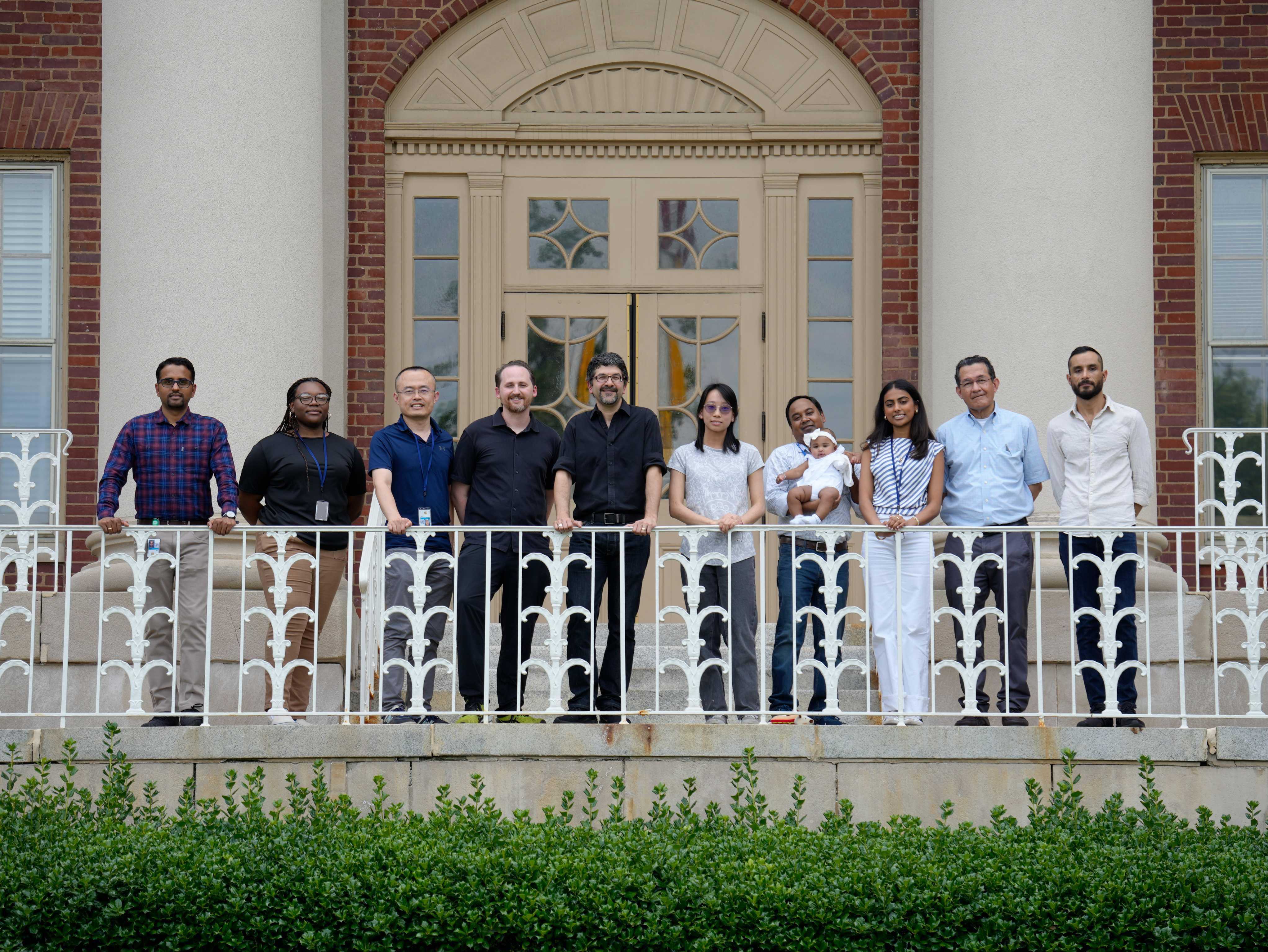 Members of the NIDDK immunoregulation section standing on a balcony and smiling.
