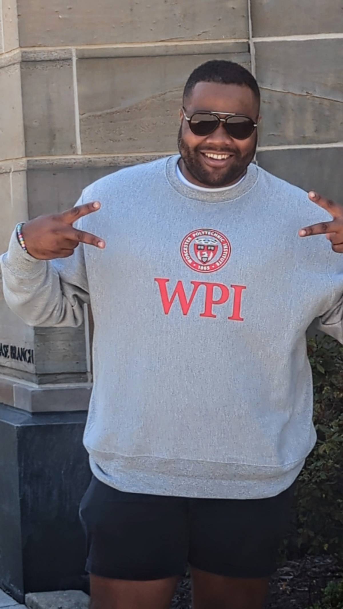 Karl-Frederic Vieux posing with a Worcester Polytechnic Institute sweatshirt.