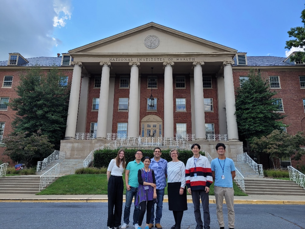 Lab members smiling and standing in front of a building