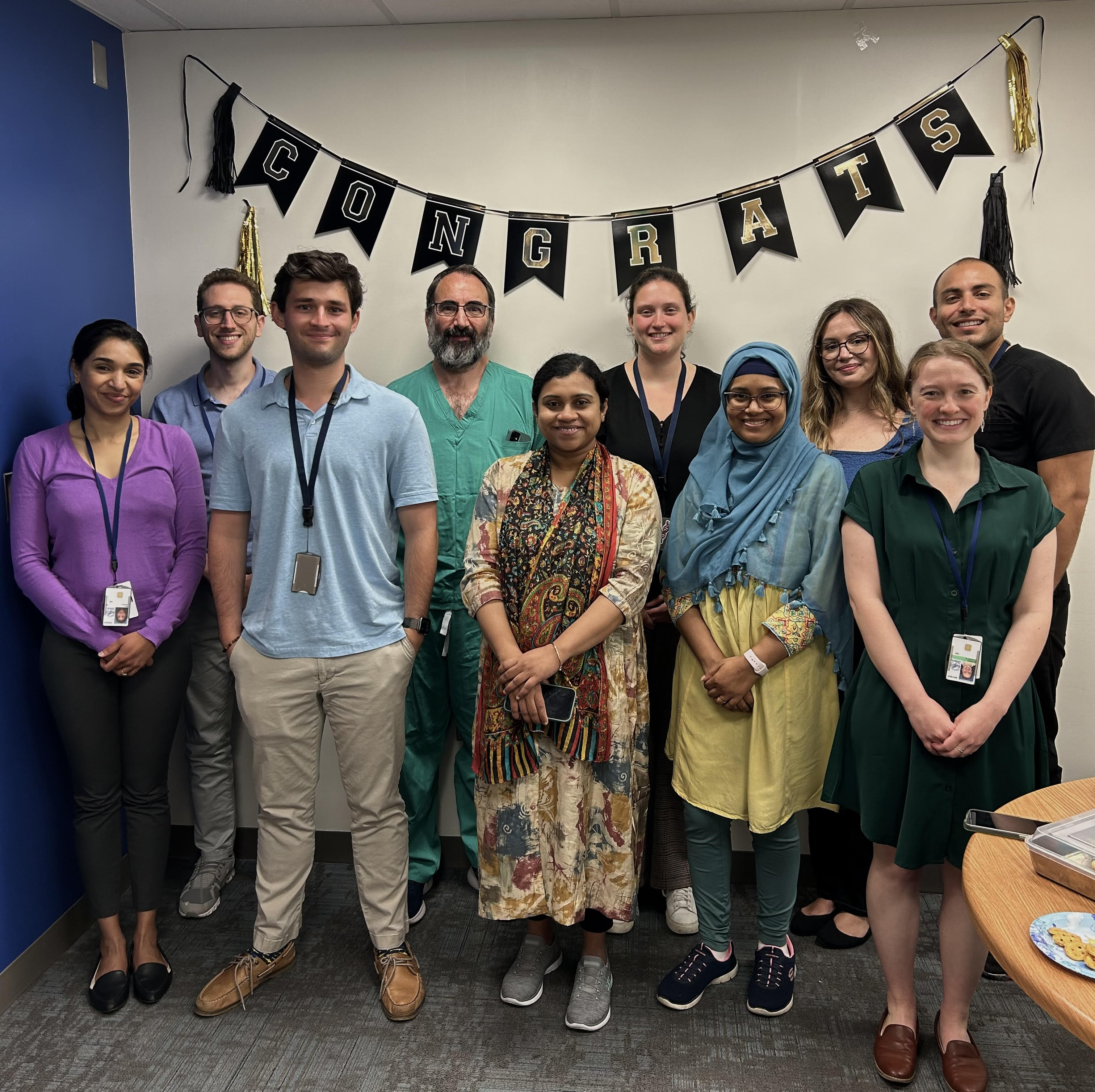 Lab Members in front of a banner that says "Congrats"