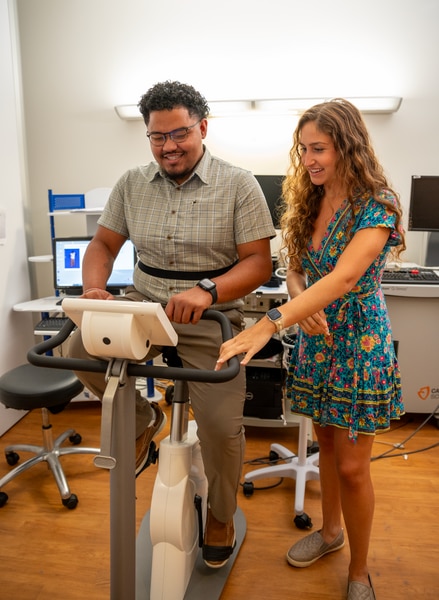 A person tries out a stationary exercise bike used for research purposes in the NIH Clinical Center 