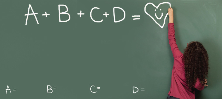 Una niña escribe "A+B+C+D = corazón" en la pizarra de la escuela.